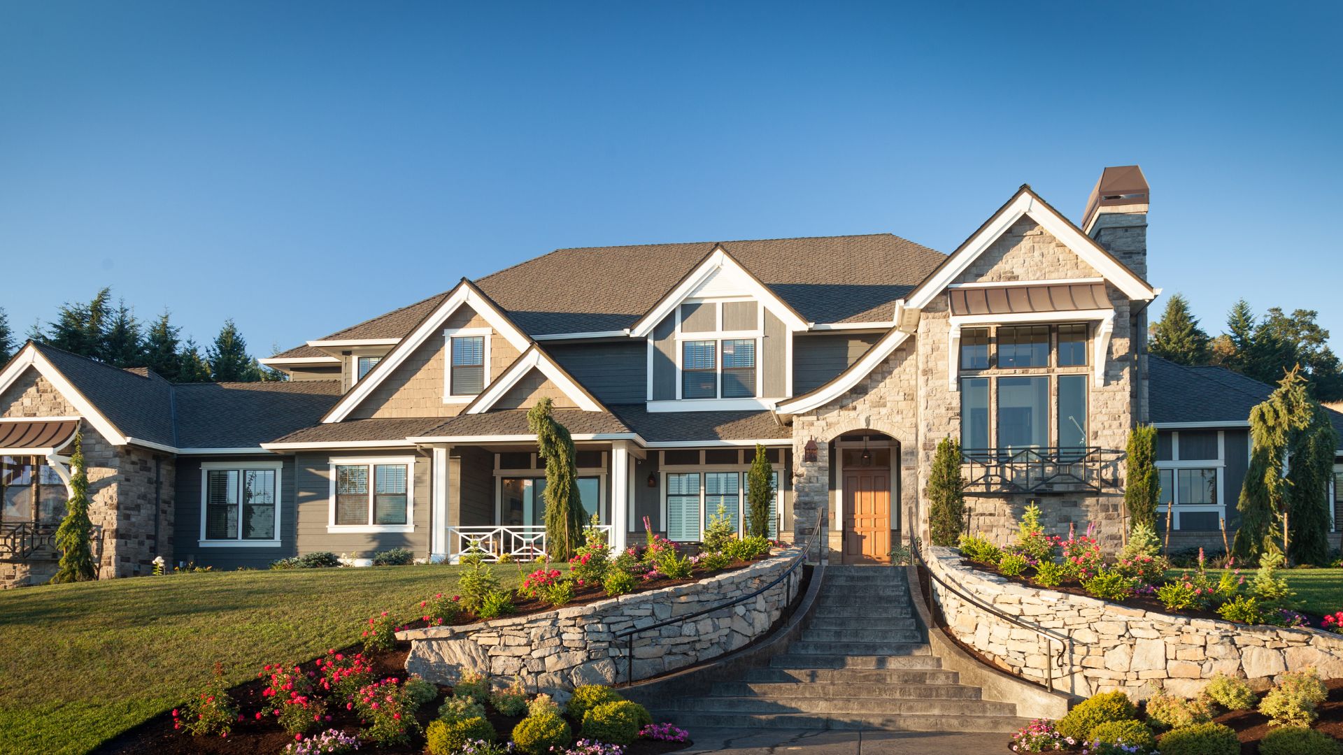 Large stone and wood two-story house with landscaped front yard