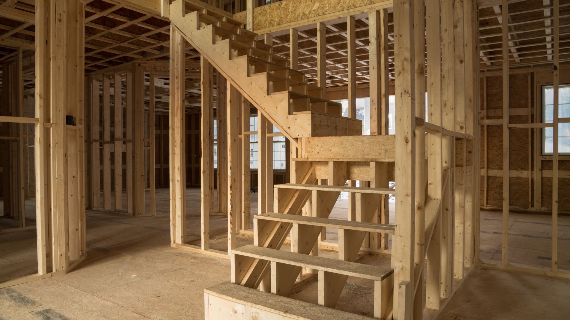 Wooden framing of house interior with staircase during construction