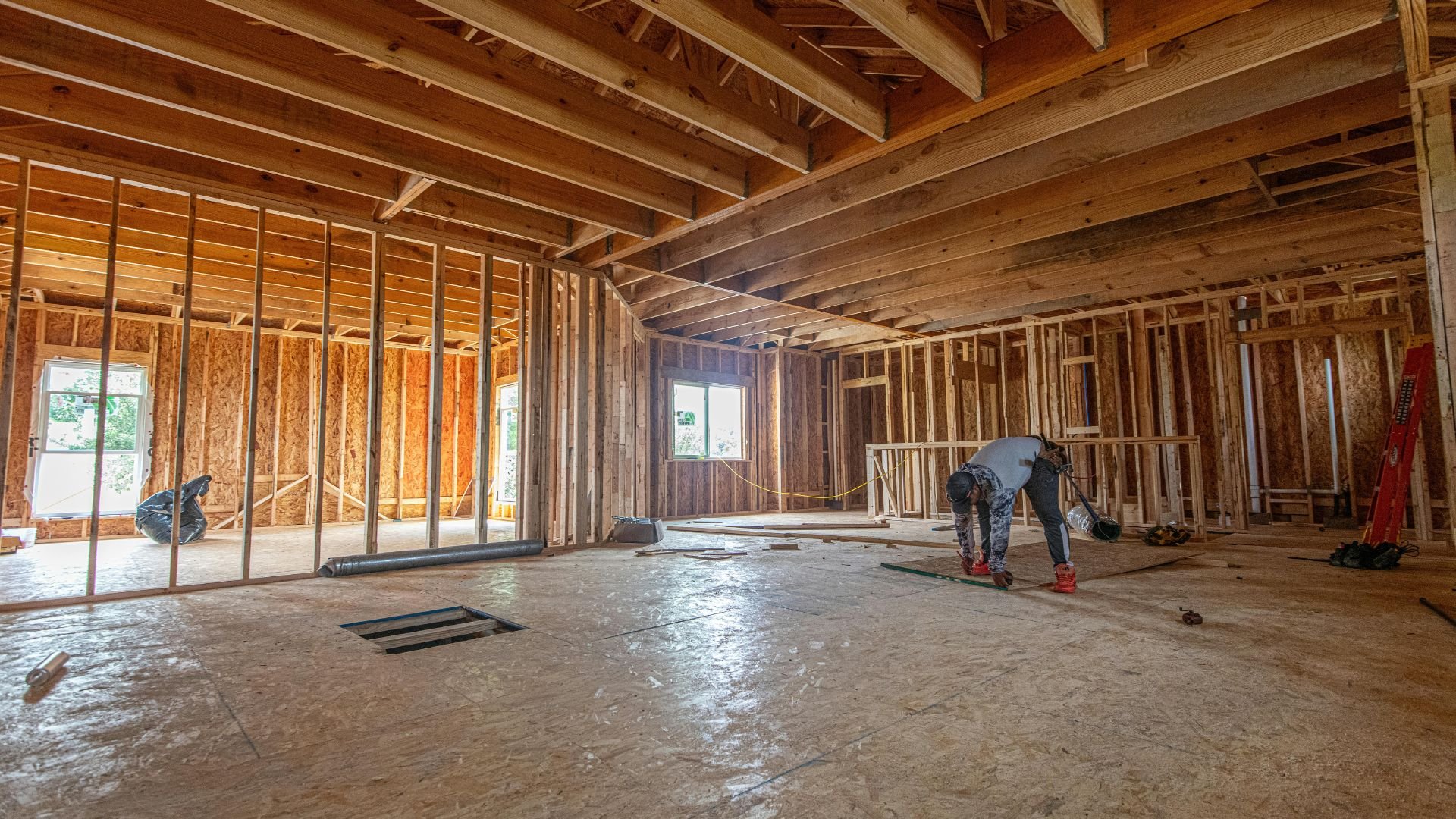 Interior of house under construction with wooden framing and workers