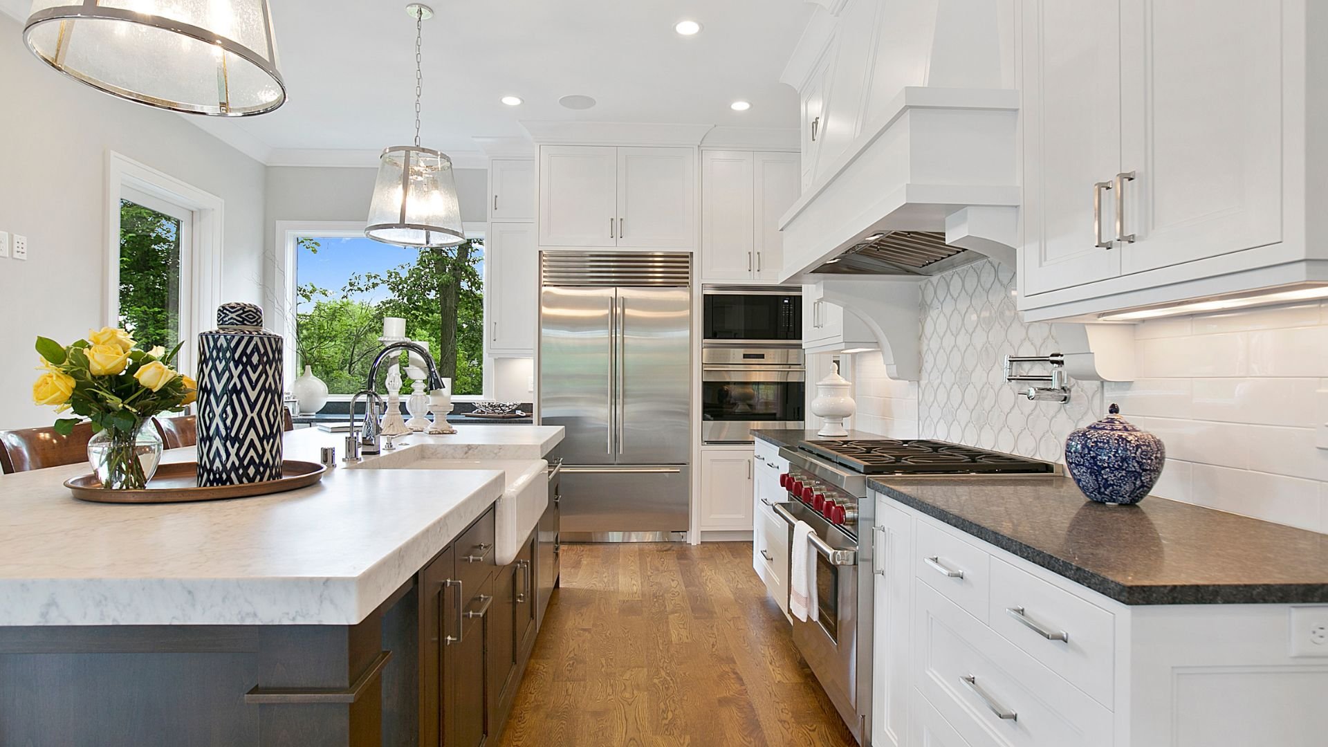 Modern white kitchen with stainless steel appliances and wooden floor