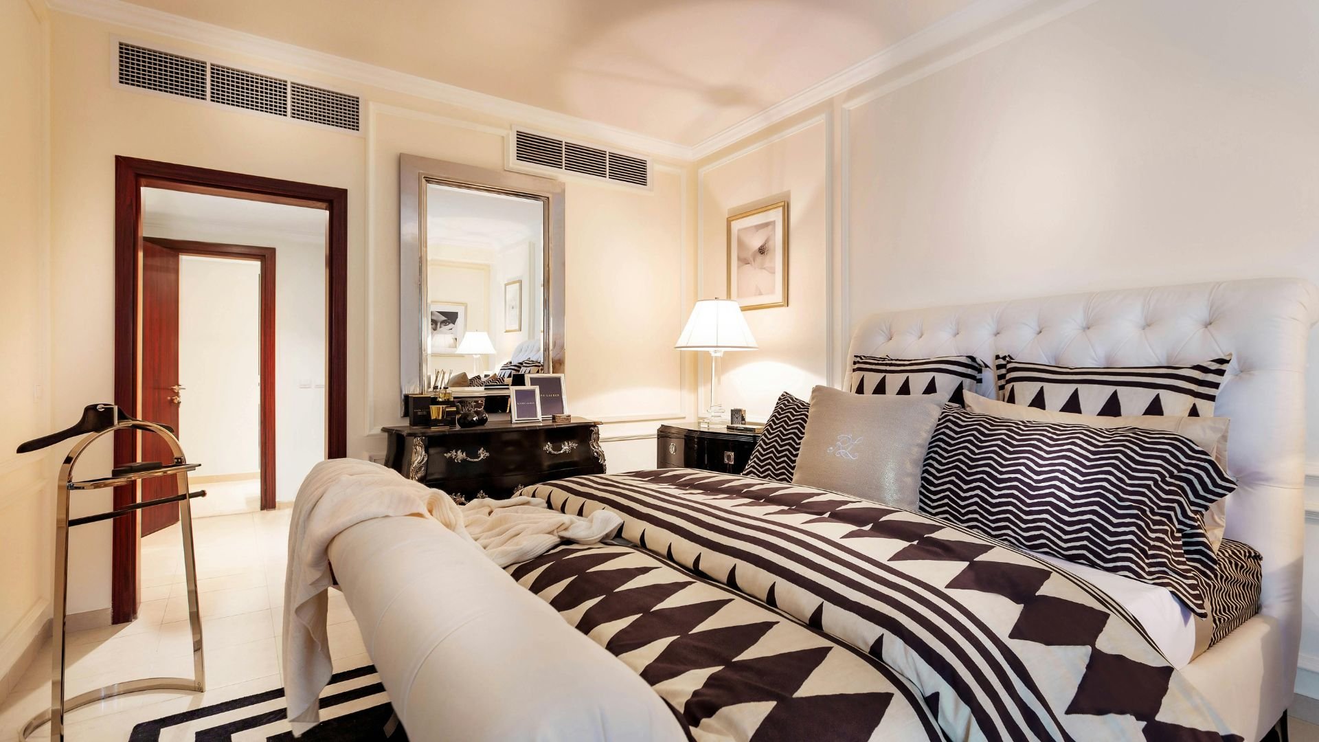 Elegant bedroom with black and white geometric bedding and tufted headboard