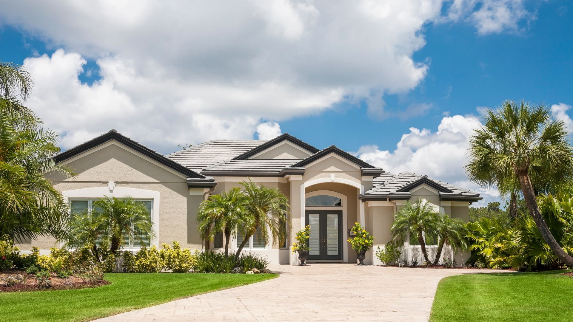Elegant Florida-style home with palm trees and manicured lawn